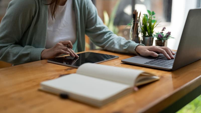 A tablet, notebook and pen on a desk, ready for working through a resource