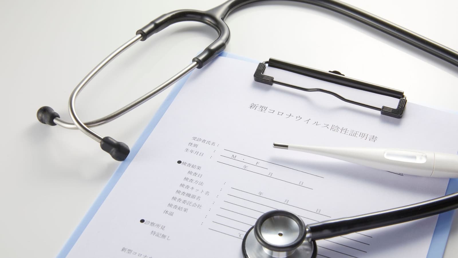 A stethoscope lying across printed paperwork on a desk