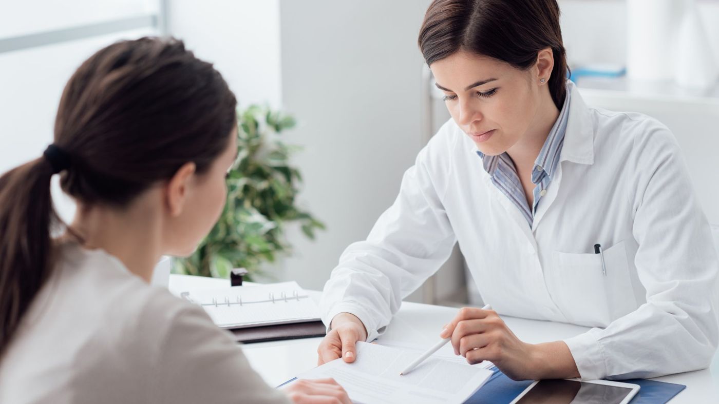 A mentor talking a healthcare professional through paperwork in a one-to-one session